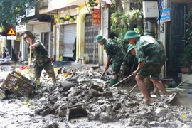 Cán bộ, chiến sỹ Trung đoàn 174, Sư đoàn 316, Quân khu 2, được huy động hỗ trợ dọn bùn, giúp người dân thành phố Yên Bái sớm ổn định cuộc sống sau đợt lũ. (Ảnh: Tuấn Anh/TTXVN)