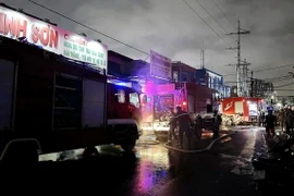 Lực lượng Cảnh sát Phòng cháy chữa cháy, cứu hộ cứu nạn tham gia chữa cháy những căn nhà, xưởng gỗ bị cháy nằm ven kênh Tàu Hủ. (Ảnh: TTXVN phát)