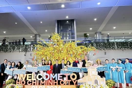 Các vị khách may mắn trên chuyến bay VN10 bay từ Paris, Pháp đến Thành phố Hồ Chí Minh nhận quà tại sự kiện.(Ảnh: Mỹ Phương/TTXVN)