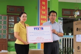 Phó Tổng giám đốc TTXVN Nguyễn Tuấn Hùng trao tặng số tiền 100 triệu đồng của TTXVN hỗ trợ Trường Mầm non Hoa Lan, phường Hồng Hà, thành phố Yên Bái khắc phục thiệt hại của bão số 3. (Ảnh: Tiến Khánh/TTXVN)