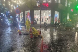 Lực lượng, phương tiện của Công ty TNHH Một thành viên Thoát nước Hà Nội ứng trực thoát nước trên phố Bà Triệu vào chiều tối 30/5 vừa qua. (Ảnh: TTXVN phát)