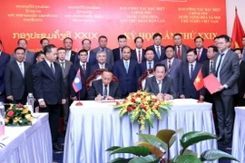Thượng tướng Võ Minh Lương (phải), Thứ trưởng Bộ Quốc phòng, Trưởng ban Ban Công tác đặc biệt Chính phủ Việt Nam và Thượng tướng Thongloi Silivong (trái), Thứ trưởng Bộ Quốc phòng, Chủ nhiệm Tổng cục Chính trị QĐND Lào, Trưởng ban Ban Công tác đặc biệt Chính phủ Lào, ký Biên bản Kỳ họp. (Ảnh: Xuân Khu/TTXVN)