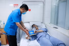 Lãnh đạo Tổng Liên đoàn Lao động Việt Nam chia sẻ, động viên và trao hỗ trợ cho nạn nhân trong vụ cháy. (Ảnh: TTXVN phát)