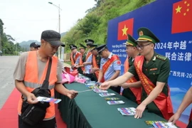 Cán bộ Đồn Biên phòng Tân Thanh, tỉnh Lạng Sơn, tuyên truyền, phát tờ rơi pháp luật biên giới tại cửa khẩu. (Ảnh: Quang Duy/TTXVN)