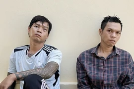 Hai anh em Sang và Oai (phải) bị bắt. (Ảnh: TTXVN phát)