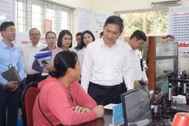 Phó Chủ tịch UBND thành phố Hà Nội Hà Minh Hải trao đổi với người dân làm thủ tục hành chính tại UBND phường Quảng An, quận Tây Hồ. (Ảnh: Nguyễn Thắng/TTXVN)