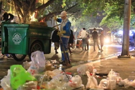 Lượng lớn rác và túi ni lông đang được công nhân của công ty Công ty TNHH MTV Môi trường Đô thị Hà Nội thu gom, xử lý. (Ảnh: Hoàng Hiếu/ TTXVN)