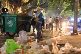 Lượng lớn rác và túi ni lông đang được công nhân của công ty Công ty TNHH MTV Môi trường Đô thị Hà Nội thu gom, xử lý. (Ảnh: Hoàng Hiếu/ TTXVN)