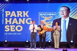 Bí thư Tỉnh ủy Bắc Ninh Nguyễn Anh Tuấn (trái) và Chủ tịch UBND tỉnh Bắc Ninh Nguyễn Hương Giang (phải) tặng hoa chúc mừng cố vấn cấp cao Bắc Ninh FC Park Hang Seo. (Ảnh: Thái Hùng/TTXVN)