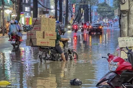 Người dân gặp khó khăn khi di chuyển do nước ngập trên đường Nguyễn Trãi, quận Ninh Kiều, thành phố Cần Thơ. (Ảnh: Thanh Liêm/TTXVN)