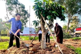 Lãnh đạo Thành ủy, UBND thành phố Thủ Dầu Một, tỉnh Bình Dương tham gia trồng cây ăn quả phủ xanh đất công để tạo công viên. (Ảnh: TTXVN phát)