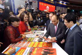 Thủ tướng Nguyễn Xuân Phúc thăm gian trưng bày của Thông tấn xã Việt Nam tại Hội báo toàn quốc 2019. (Ảnh: Huy Hùng/TTXVN)