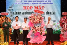 Ông Nguyễn Minh Triết, nguyên Chủ tịch nước (bên phải) và các lãnh đạo huyện Dầu Tiếng. (Ảnh: TTXVN phát)