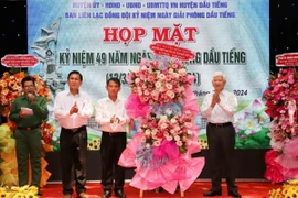 Ông Nguyễn Minh Triết, nguyên Chủ tịch nước (bên phải) và các lãnh đạo huyện Dầu Tiếng. (Ảnh: TTXVN phát)