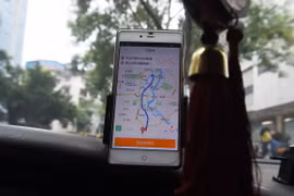 Tài xế taxi sử dụng ứng dụng gọi xe Didi Chuxing tại Quế Lâm, Trung Quốc. (Ảnh: AFP/TTXVN)
