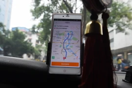 Tài xế taxi sử dụng ứng dụng gọi xe Didi Chuxing tại Quế Lâm, Trung Quốc. (Ảnh: AFP/TTXVN)