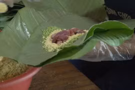 Một công đoạn gói bánh chưng gù (Ảnh: Lâm Phan/Vietnam+)