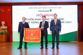 Thừa ủy quyền của Thủ tướng Chính phủ, Phó Thống đốc NHNN Đoàn Thái Sơn trao Cờ thi đua của Thủ tướng Chính phủ cho Vietcombank tại Hội nghị triển khai hoạt động kinh doanh năm 2021. (Ảnh: Vietnam+)