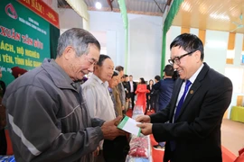 Tổng Giám đốc NHCSXH Dương Quyết Thắng tặng quà cho các gia đình có công với cách mạng, gia đình chính sách và hộ nghèo tại xã Lam Cốt. (Ảnh: CTV/Vietnam+)