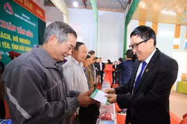 Tổng Giám đốc NHCSXH Dương Quyết Thắng tặng quà cho các gia đình có công với cách mạng, gia đình chính sách và hộ nghèo tại xã Lam Cốt. (Ảnh: CTV/Vietnam+)