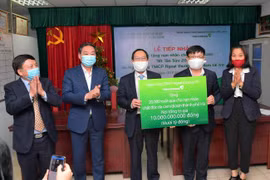 Đại diện Vietcombank trao biển tượng trưng số tiền 10 tỷ đồng quà Tết cho 20.000 nạn nhân chất đôc da cam/dioxin thành phố Hà Nội. (Ảnh: Vietnam+)