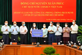 Trong khuôn khổ chuyến thăm và làm việc của Chủ tịch nước Nguyễn Xuân Phúc tại TP.HCM, bà Nguyễn Đức Thạch Diễm (giữa) Tổng Giám đốc Sacombank đại diện ngân hàng ủng hộ 30 tỷ đồng vào công tác phòng chống dịch bệnh. (Ảnh: CTV/Vientnam+)