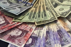 Đồng bảng Anh và USD. (Ảnh: AFP/TTXVN)
