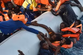 Người di cư rơi xuống nước trong sự cố lật thuyền ngoài khơi Libya ngày 3/11. (Ảnh: AFP/TTXVN)