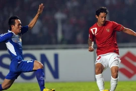 Tiền đạo Irfan Bachdim (phải), đội Indonesia trong pha tranh bóng với cầu thủ Kovanh Namthavixay, đội Lào. (Ảnh: AFP/TTXVN)