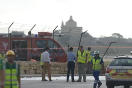Lực lượng cứu hộ làm nhiệm vụ tại hiện trường vụ tai nạn máy bay. (Ảnh: AFP/TTXVN)