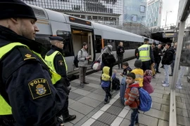 Cảnh sát kiểm tra nhóm người nhập cư tại sân ga ở Malmo. (Ảnh: AFP/TTXVN)