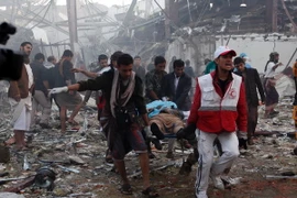 Chuyển thi thể nạn nhân khỏi hiện trường sau vụ không kích của liên quân xuống Sanaa ngày 8/10 vừa qua. (Ảnh: AFP/TTXVN)