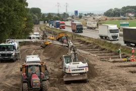 Các công nhân xây dựng tường chắn ở trại tị nạn gần Calais. (Ảnh: AFP/TTXVN)