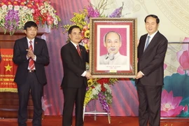 Chủ tịch nước Trần Đại Quang tặng bức ảnh chân dung "Chủ tịch Hồ Chí Minh" cho Đảng bộ, chính quyền và nhân dân huyện Hoa Lư. (Ảnh: Nhan Sáng/TXVN)