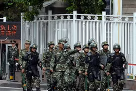Cảnh sát bán quân sự Trung Quốc tuần tra một đường phố ở Urumqi, Tân Cương. (Nguồn: AFP)