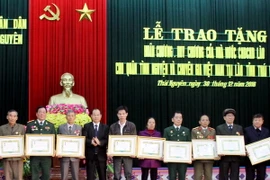 Ông Phomma Sitsena, đại diện Đại sứ quán Lào tại Việt Nam trao Huân, Huy chương của nước Cộng hòa Dân chủ nhân dân Lào cho các cán bộ, quân tình nguyện Việt Nam tại Lào. (Ảnh: Thu Hằng/TTXVN)