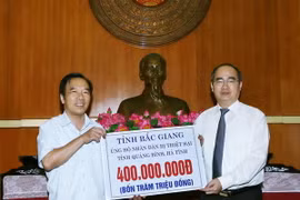 Chủ tịch Ủy ban Trung ương Mặt trận Tổ quốc Việt Nam Nguyễn Thiện Nhân tiếp nhận 400 triệu đồng của cán bộ và nhân dân tỉnh Bắc Giang ủng hộ đông bào. (Ảnh: Nguyễn Dân/TTXVN)