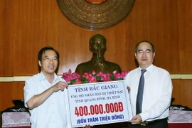 Chủ tịch Ủy ban Trung ương Mặt trận Tổ quốc Việt Nam Nguyễn Thiện Nhân tiếp nhận 400 triệu đồng của cán bộ và nhân dân tỉnh Bắc Giang ủng hộ đông bào. (Ảnh: Nguyễn Dân/TTXVN)
