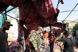 Lực lượng an ninh Iraq điều tra tại hiện trường vụ đánh bom ở quận Shaab ngày 15/10. (Ảnh: AFP/TTXVN)