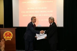 Đại sứ Việt Nam tại Ukraine Nguyễn Minh Trí (bên trái) tiếp nhận tiền quyên góp. (Ảnh:Dương Trí/Vietnam+)