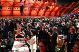 Các đại biểu hoan nghênh quyết định thông qua Thỏa thuận Paris 2015 về chống biến đổi khí hậu tại Le Bourget ngày 12/12 vừa qua. (Ảnh: AFP/TTXVN)