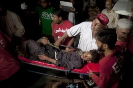 Các nhân viên cứu hộ Pakistan và tình nguyện viên đưa nạn nhân bị thương của một vụ nổ bom tại một ngôi đền Sufi đến bệnh viện. (Nguồn: AP)