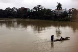 Thả lưới trên sông Như Ý, trong khi nước lũ đang cao, bất chấp nguy hiểm. (Ảnh: Quốc Việt/Vietnam+)