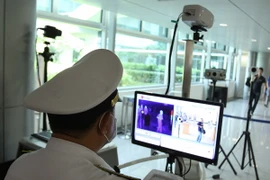 Khách đến từ những nước có dịch MERS-CoV được kiểm tra khu kiểm dịch sân bay Tân Sơn Nhất. (Ảnh: Phương Vy/TTXVN)