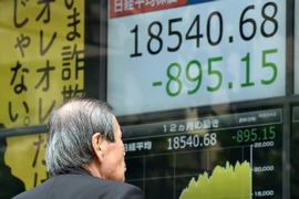 Nhà đầu tư theo dõi bảng điện tử chỉ số chứng khoán tại sàn giao dịch ở Tokyo, Nhật Bản ngày 24/8. (Nguồn: AFP/TTXVN)