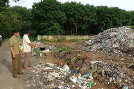 Bãi rác khổng lồ nằm ngay bên cạnh đường tại Bình Phước. (Ảnh: Đậu Tất Thành/TTXVN)