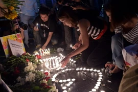 Người dân Thái Lan thắp nến bên ngoài đền thờ Erawan, tưởng niệm các nạn nhân vụ đánh bom. (Nguồn: AFP/TTXVN)