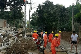 Công nhân Điện lực Yên Bái đang khẩn trương sửa chữa lại hệ thống lưới điện bị hư hỏng sau mưa lũ. (Ảnh: TTXVN phát)