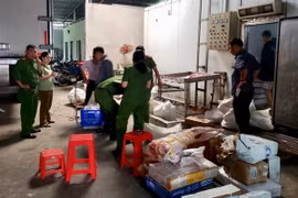 Công an thành phố Cần Thơ kiểm tra và thu giữ hàng chục tấn thực phẩm không rõ nguồn gốc tại cơ sở Hồng Thắm. (Ảnh: Thanh Sang/TTXVN)