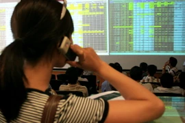 Nhà đầu tư theo dõi diễn biến thị trường trên sàn giao dịch chứng khoán Bảo Việt. (Ảnh: Phạm Hậu/TTXVN)